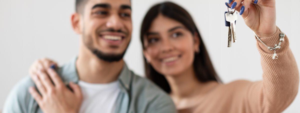 Happy couple showing off house keys.