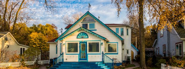 A blue and white house in fall.