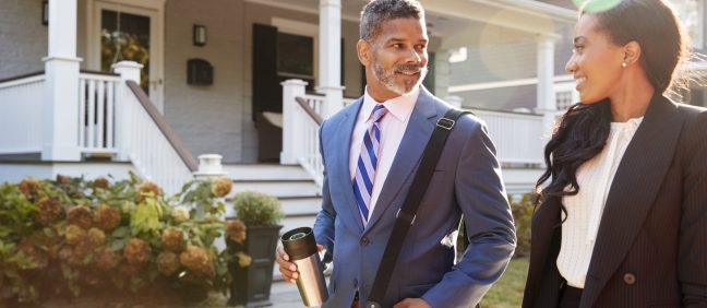 Business Couple Leaving Suburban House For Commute To Work