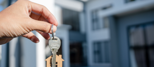 home with someone holding keys up to it outside that used escrow