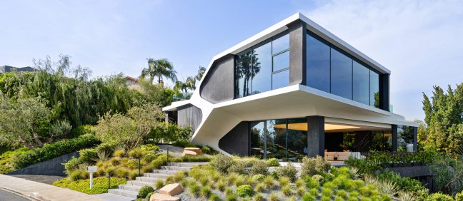 An exterior shot of a modern house in Los Angeles. The facade is completely made of glass.