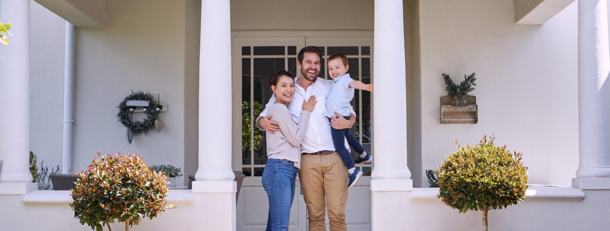 Family standing in front of their new home