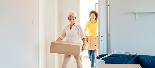 mom and daughter bringing in boxes new home