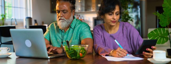 Indian middle-aged couple at home managing finances.