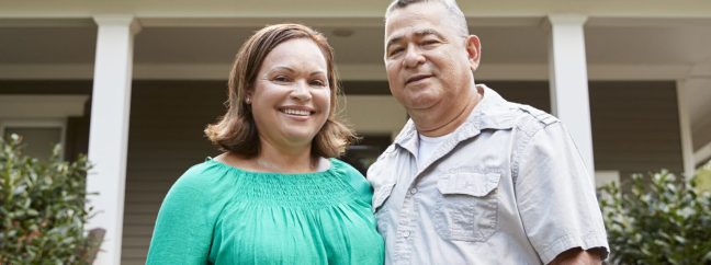Portrait Of Smiling Senior Couple In Front Of Their Home