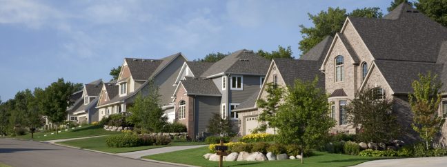 Street and houses of upscale neighborhood on a summer's day.